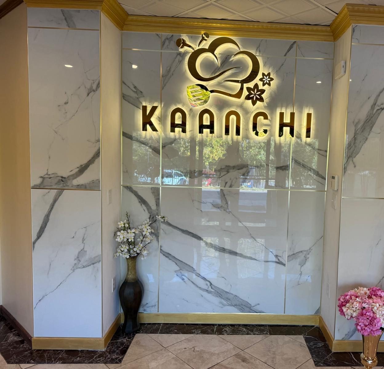 The illuminated Kaanchi sign on the marble entrance wall