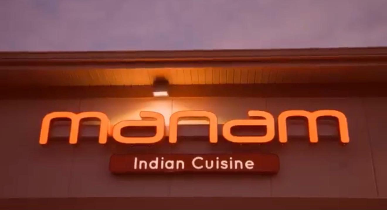 Manam's illuminated sign at dusk